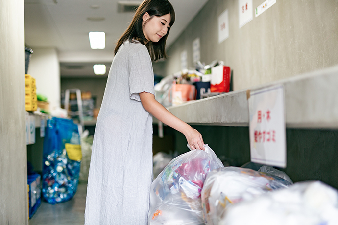 マンションでゴミ捨てをする女性